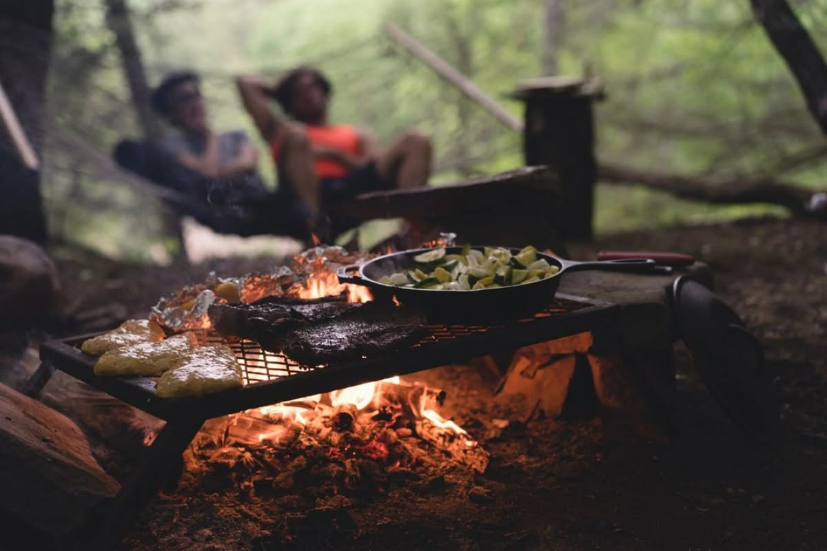Cooking over an open campfire grill at dusk
