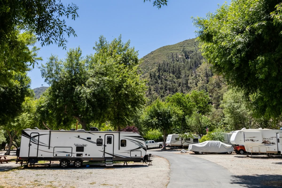 Travel trailers parked under green mountains